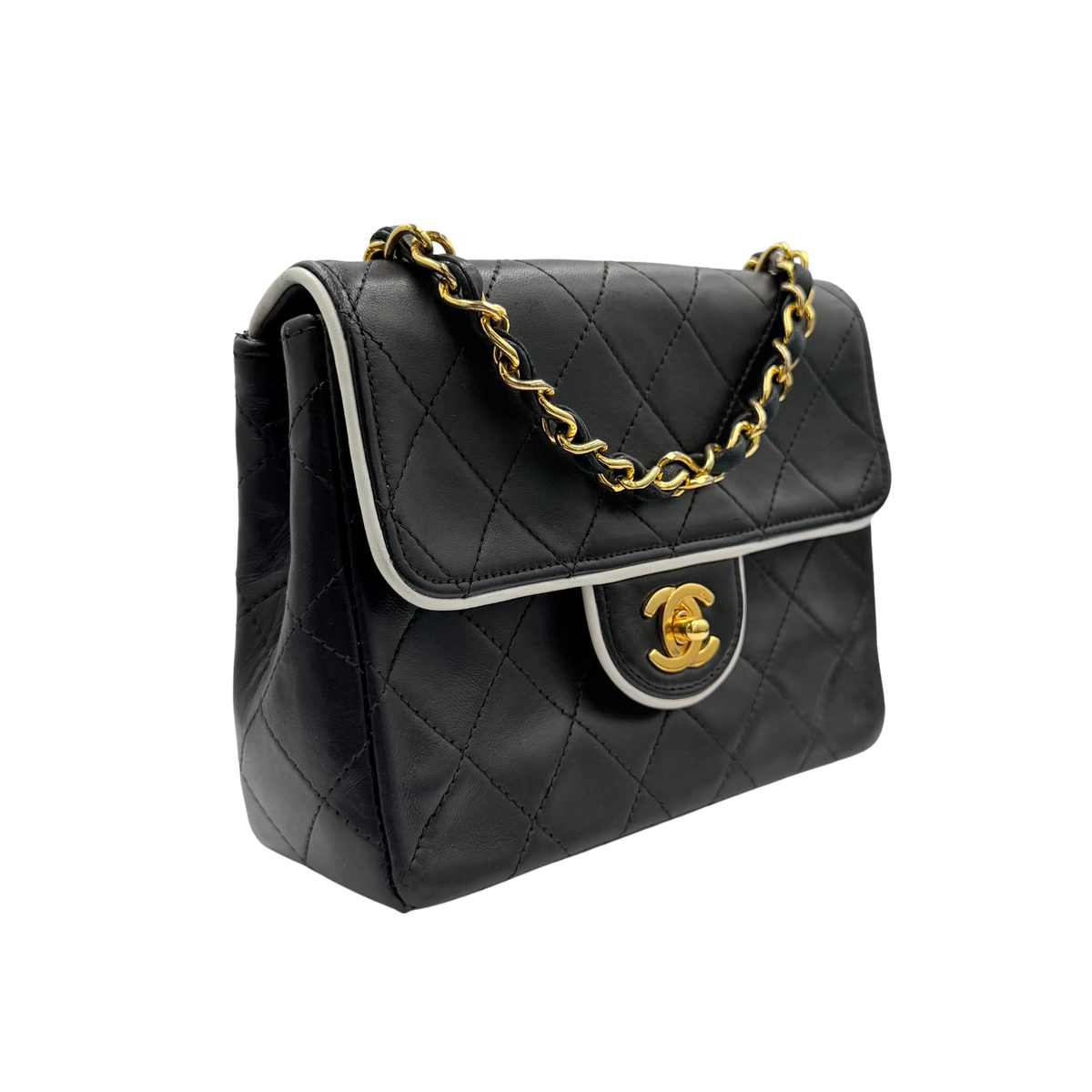 Chanel black quilted lambskin mini flap, front three-quarter view with contrast piping